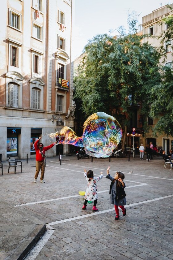 Children Chasing a Giant Soap Bubble in a Plaza