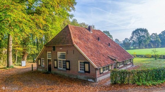 Traditional Dutch farmhouse beside autumn woodland and pasture