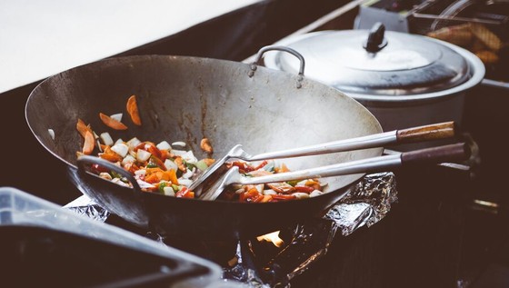 Vegetables Frying in a Wok Over Open Flame