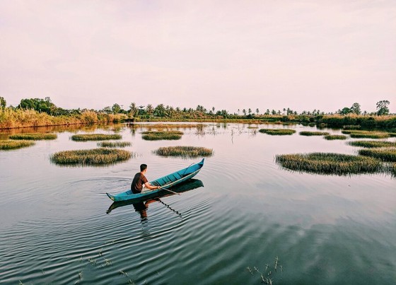 Fisherman in a Canoe on Flooded Wetlands